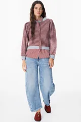 Sweater de punto con diseño de rayas horizontales en color bordó y gris, con mangas abullonadas y cuello redondo. Incluye un detalle de cuello de camisa a rayas incorporado con lazo frontal.