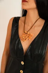 Vestido largo negro de cuero, sin mangas, con escote en V y cierre frontal de botones de guampa.