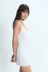 Pijama de dos piezas compuesto por una musculosa con escote pronunciado y detalles de puntilla en los bordes, y un short a juego con terminación ondulada. Presenta un diseño de rayas horizontales tenues en tono gris claro.