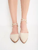 Zapato Lady color beige, de cuero, con punta fina y tiras cruzadas con hebilla alrededor del tobillo.