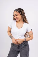 Remera corta de punto canalé color rosa, con escote en V, mangas cortas con volados y cierre frontal con botones.