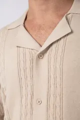 Camisa de punto de manga corta con cuello tipo bowling y cierre frontal de botones. Presenta un diseño texturizado con franjas verticales y detalles de contraste en blanco en los bordes de las mangas.