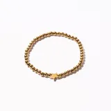 Pulsera elástica dorada con cuentas redondas y dije de estrella.