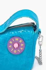 Bolso bandolera tipo hobo de piel color amarillo flúor, tamaño mini, con cierre de cremallera, asa de mano con apliques de caritas sonrientes y asa bandolera metálica extraíble.