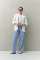 Pantalón negro de corte recto y tiro alto, confeccionado en denim con costuras a contratono en color blanco. Presenta bolsillos frontales tipo parche y cierre frontal con botón y cremallera.