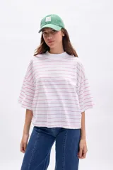 Remera blanca de manga corta ancha con cuello alto, estampada con finas rayas horizontales rosas.