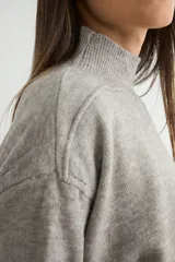 Conjunto de dos piezas compuesto por un sweater de cuello alto con aberturas laterales en el ruedo y un pantalón de corte recto y holgado, ambos confeccionados en tejido de punto suave.