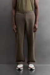 Pantalón jogger relaxed fit Zara Athleticz de tejido técnico compacto elástico con mezcla de algodón. Presenta cintura elástica ajustable con cordón, bolsillos laterales en la cadera, bolsillo trasero con cierre de cremallera, bajo ajustable con elástico y detalle de logo estampado en la pernera.