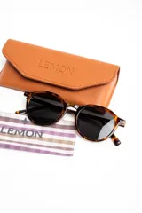 Lentes de sol polarizados con armazón redondo de carey marrón y micas oscuras.