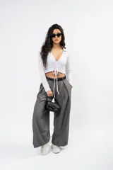 Pantalón de vestir gris de corte sastrero, con pinzas frontales, diseño de pierna ultra ancha y tiro medio.