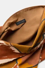 Maxi bolsa de hombro confeccionada en algodón, con diseño estampado en tonos marrones y beige, de gran capacidad y asas superiores.