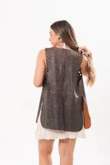 Chaleco de silueta relajada confeccionado en cuero, con detalles de ojalillos metálicos a lo largo del diseño.