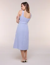 Vestido midi abotonado verde melange, con escote recto, tirantes anchos y falda de calce recto con vuelo sutil. Tiene abotonadura frontal completa con botones estilo carey, cinto textil con hebilla para ajustar la cintura y bolsillos laterales.