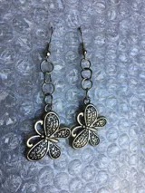 Par de caravanas colgantes de fantasía plateada con forma de mariposa.