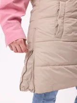 Chaleco largo acolchado color beige, con capucha forrada en sherpa, cierre frontal con cremallera y botones a presión, y bolsillos laterales.