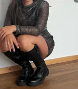 Bota de caña media de cuero negro, con suela track y cierre lateral.