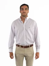 Camisa de corte clásico confeccionada en 100% algodón, con diseño de rayas verticales en tonos rosa y azul sobre fondo blanco. Presenta cuello con botones, cierre frontal abotonado y bolsillo en el pecho con logo bordado.