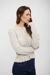 Buzo de tejido de punto en color gris claro, con diseño de textura acanalada vertical y terminaciones onduladas en cuello, puños y ruedo.