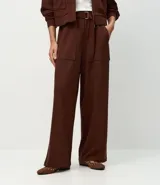 Pantalón de corte wide leg color marrón, con cintura alta, elástico posterior, bolsillos delanteros amplios y cinta con hebilla para lazo en la cintura.