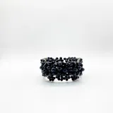 Pulsera semirrígida de cristales negros montada sobre hilo metálico plateado.