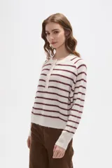 Sweater de punto a rayas horizontales en tonos marrón y blanco, con cuello redondo y cierre frontal parcial con botones. Presenta un diseño holgado de manga larga con puños y ruedo acanalados.