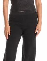 Pantalón palazzo de tiro alto confeccionado en tejido con acabado brillante tipo lurex, con pretina ancha elastizada y corte amplio.