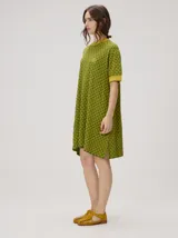Vestido corto de algodón con estampa geométrica en tonos verde y amarillo, cuello redondo y mangas cortas con puños en color contrastante.