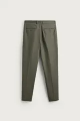 Pantalón de traje regular fit de lino color verde militar, con bolsillos laterales y bolsillos traseros de doble vivo con botón. Cierre frontal con cremallera y botón.
