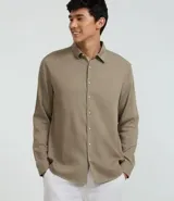 Camisa masculina de manga larga color beige, con cuello inglés y abotonado frontal. Corte comfort.