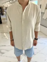 Camisa oversize de lino color beige, con cuello mao y mangas largas.