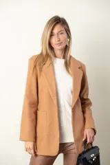 Blazer color camel de paño, corte recto, con solapas y cierre frontal con un botón.
