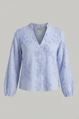 Blusa celeste de manga larga con diseño de rayas y bordado en relieve con motivos florales. Presenta escote en V y mangas abullonadas con puños elásticos.