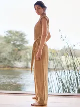 Mono color arena de lino, con cuello mao, cierre frontal con cremallera, mangas cortas y cinturón de lazo.