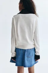 Buzo de punto fino con diseño de hombros descubiertos y escote redondo amplio. Presenta un corte holgado con terminaciones acanaladas en el cuello, los puños y el bajo.