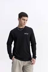 Remera de manga larga color bordó con escote redondo y estampado en la espalda que dice "Mistral Studio limited edition" en blanco.