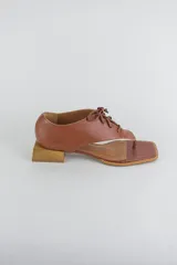 Sandalias de cuero color beige con diseño de ojota acordonada en el empeine, puntera cuadrada y taco bajo cuadrado.