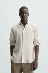 Camisa de corte regular fit confeccionada en tejido de lino, con cuello solapa, manga larga con puños abotonados y cierre frontal de botones.