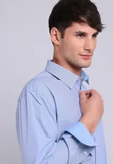 Camisa de vestir Arrow celeste con micro-puntos blancos, corte entallado, mangas largas, cuello tradicional y puños ajustables con botones.