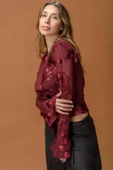 Blusa de encaje color bordó con diseño floral en relieve, cuello redondo, mangas largas acampanadas y corte cropped.