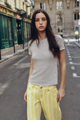 Camiseta de manga corta gris melange con cuello redondo y costuras decorativas visibles en los hombros.