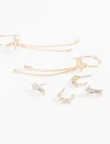 Set de aros dorados con strass, incluye tres pares: aros tipo botón con forma de barra, aros tipo argolla pequeña y aros tipo argolla grande con dije de estrella y colgantes de cadena con strass.