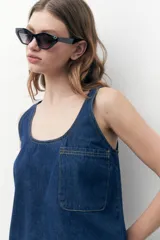 Blusa sin mangas de jean azul oscuro con escote redondo y bolsillo de parche en el pecho.