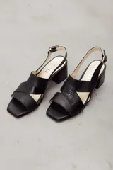 Sandalia de cuero vacuno color marrón, con taco ancho, diseño de tiras anchas cruzadas y tira con textura. Cuenta con tira ajustable al tobillo con hebilla metálica.