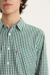 Camisa de manga larga a cuadros verdes y blancos, con cuello clásico, cierre con botones y bolsillo en el pecho.