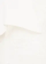 Camisa de corte recto y diseño clásico con cuello camisero, manga larga con puños abotonados y cierre frontal de botones ocultos. Presenta parches decorativos sutiles en la parte frontal.