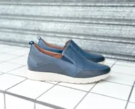 Zapatos tipo pancha sin cordones, fabricados en cuero azul marino con detalles texturizados y suela blanca de poliuretano.