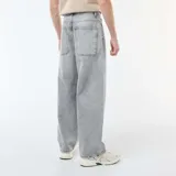 Pantalón de jean con corte baggy, color gris lavado, de tiro medio y pierna ancha.