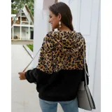 Campera tipo polar con cierre frontal, diseño combinado con estampado animal print en la parte superior y tejido de peluche blanco en la parte inferior. Cuenta con capucha con cordones ajustables y dos bolsillos frontales.