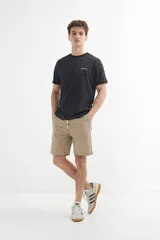 Remera de manga corta color crudo con textura de rayas horizontales y bordado pequeño en el pecho.