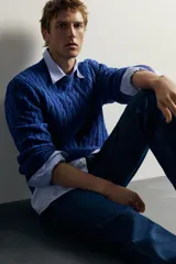 Sweater de punto verde con diseño de trenzas, cuello redondo y manga larga, de corte regular fit y acabados en rib.